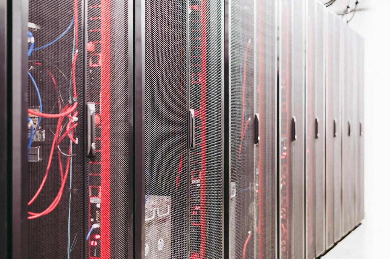 Row of server racks with visible cabling inside a data center corridor