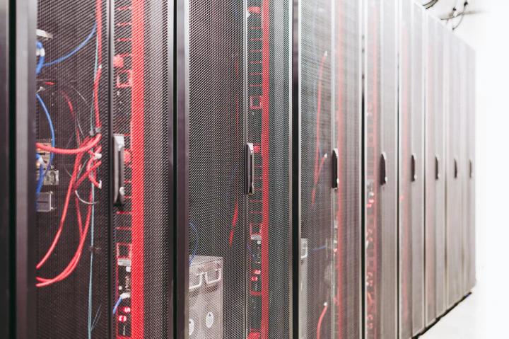 Row of server racks with visible cabling inside a data center corridor