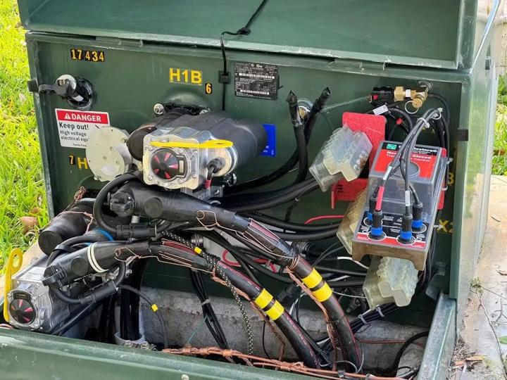 Open electrical transformer cabinet showing DTM, control modules, cables, connectors, and warning labels