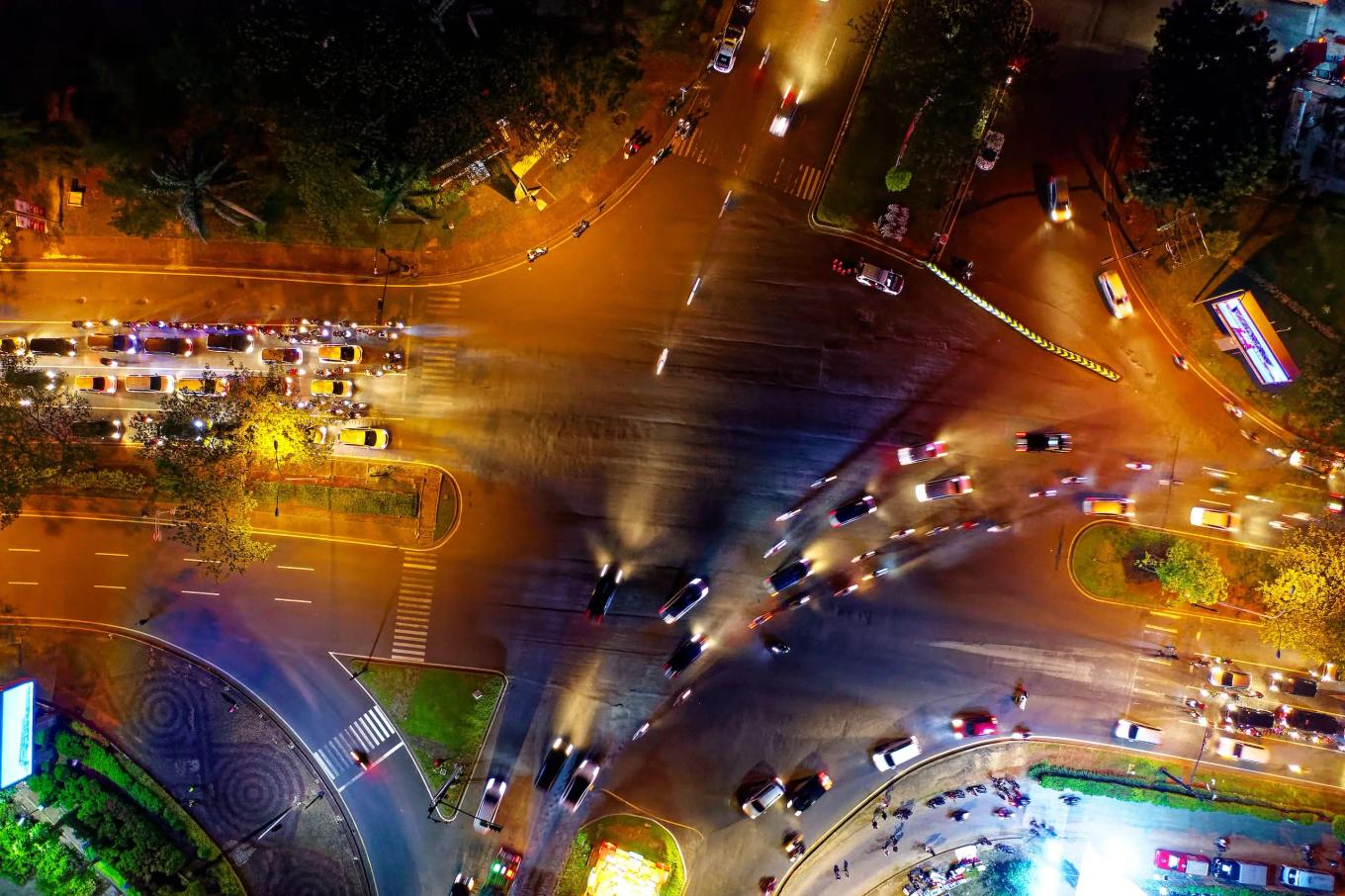 Aerial view of a busy city intersection at night with vehicle light trails