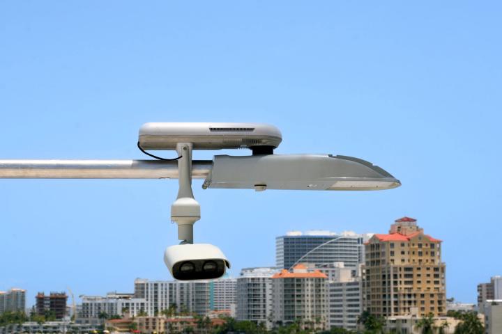 UbiHub AI+ with mounted camera overlooking urban buildings under a clear sky