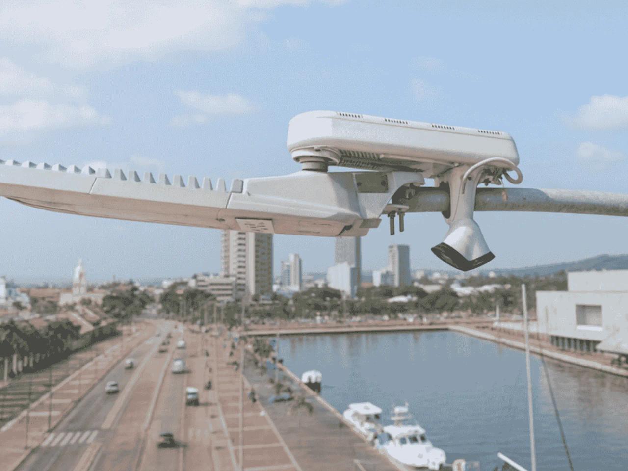 Streetlight-mounted UbiHub AI+ overlooking a roadway and waterfront with buildings in the background