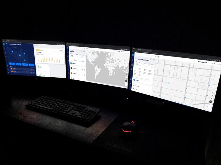 Multiple wall-mounted screens displaying maps and data dashboards in Network Operations Center room