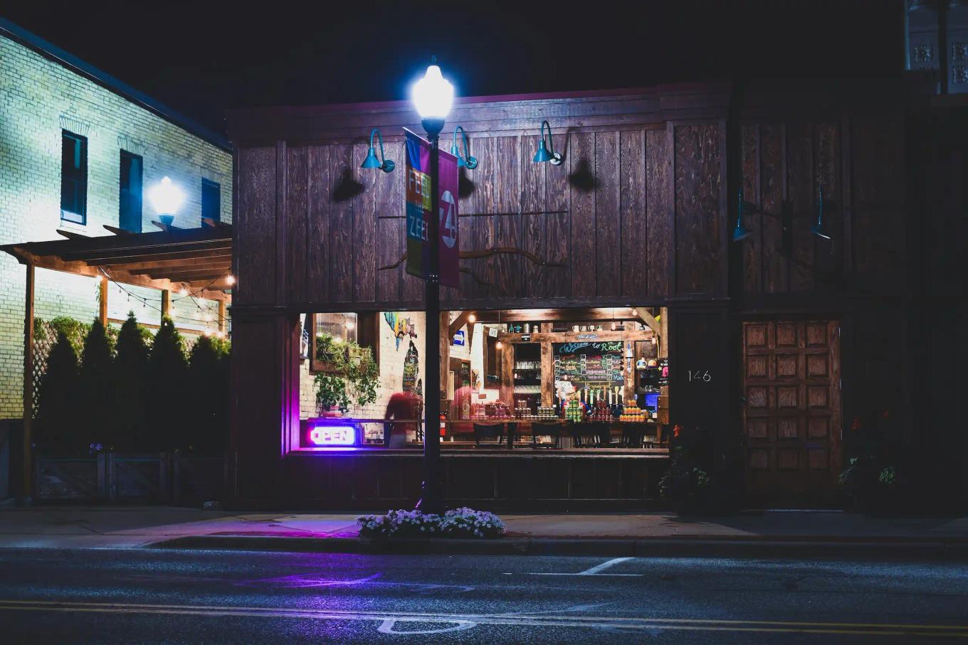 Streetlight illuminating a small commercial storefront and sidewalk at night