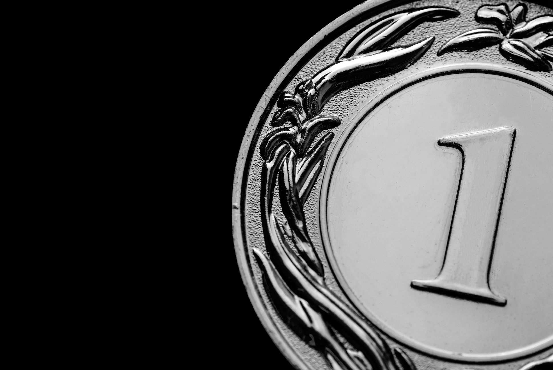 Black and white close up image of a first place medal