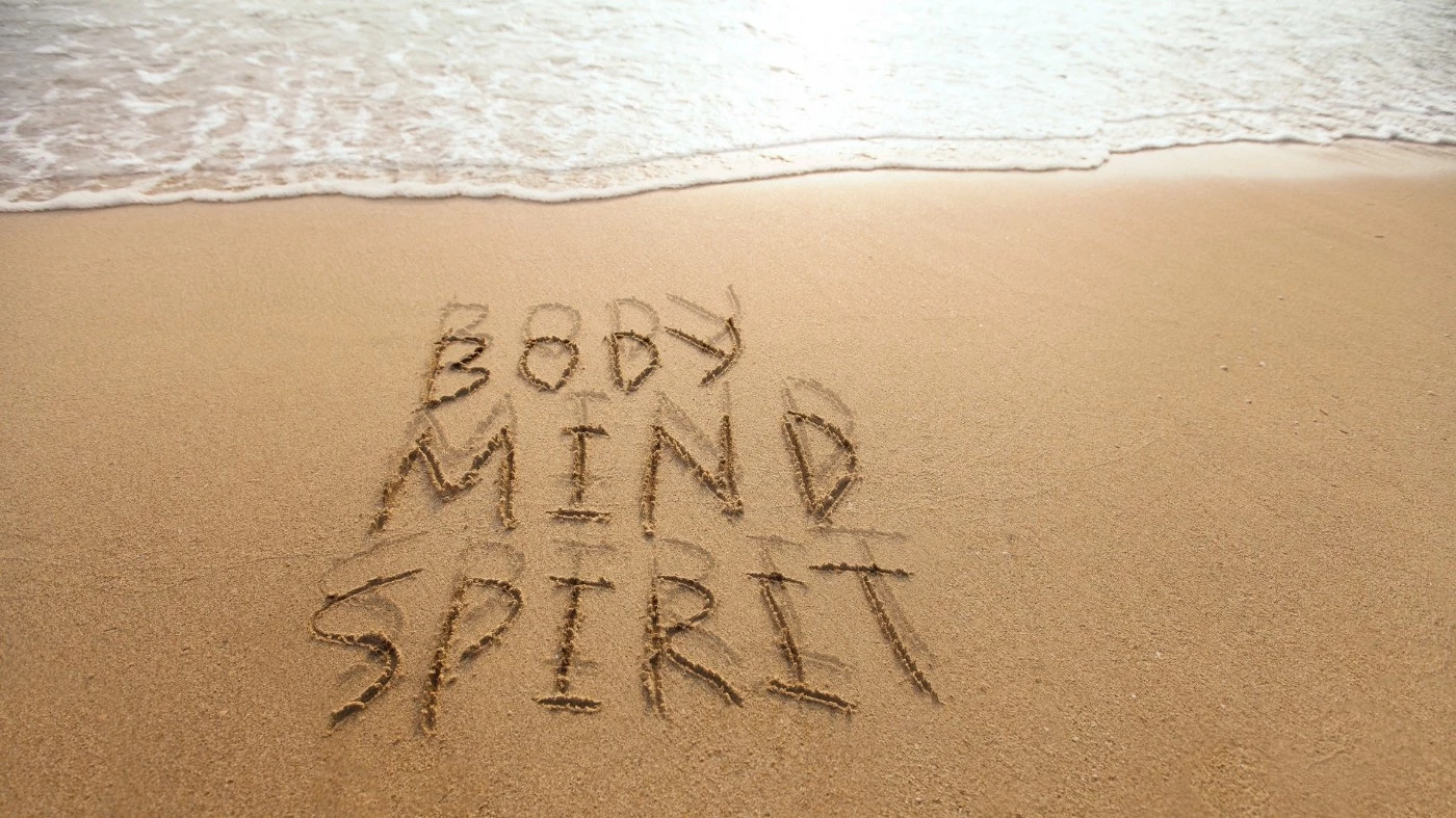 Body, mind, and spirit drawn into the sand with the ocean shoreline at the top.