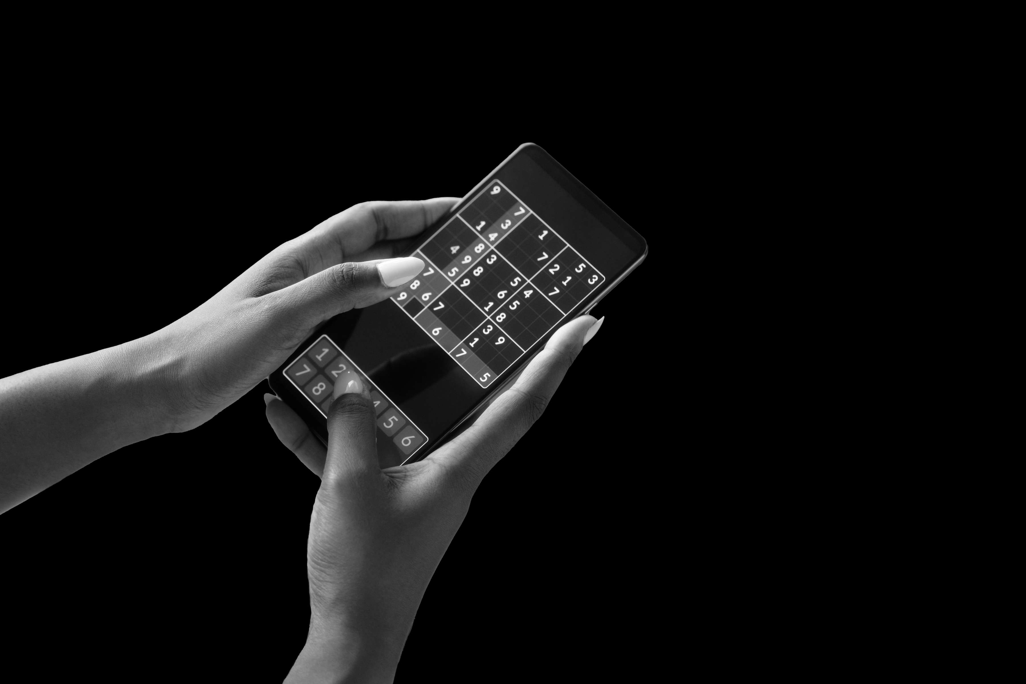 Black and white image of a woman's phone playing a game