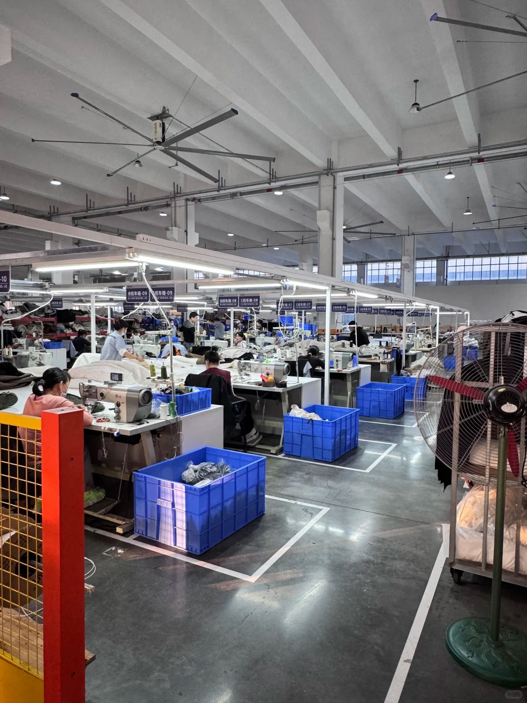 Upholstery sewing production line in Chinese furniture factory, workers cutting and stitching sofa fabric, standardized workstation layout for custom soft furniture