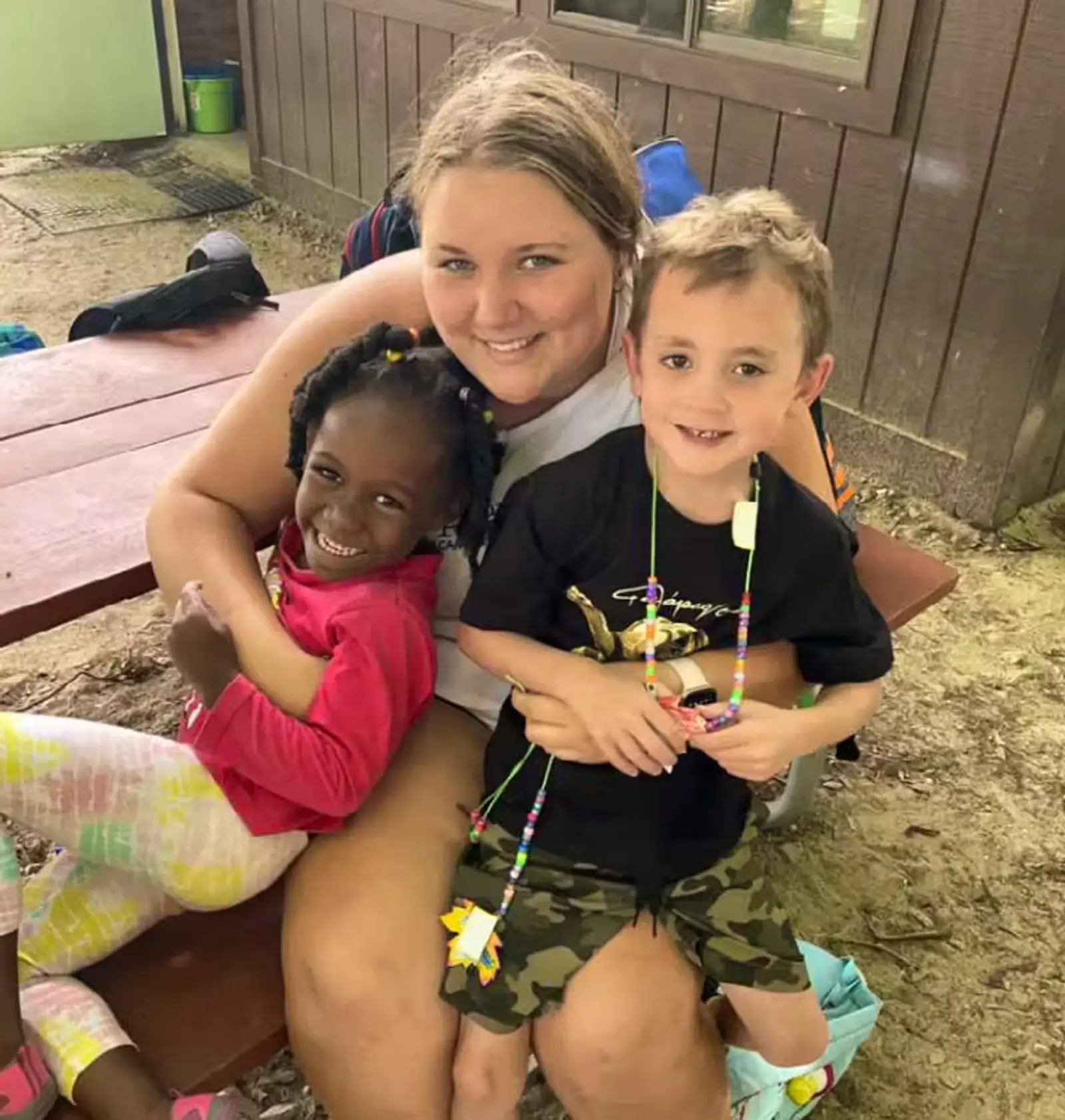 A woman sitting on a bench with two children