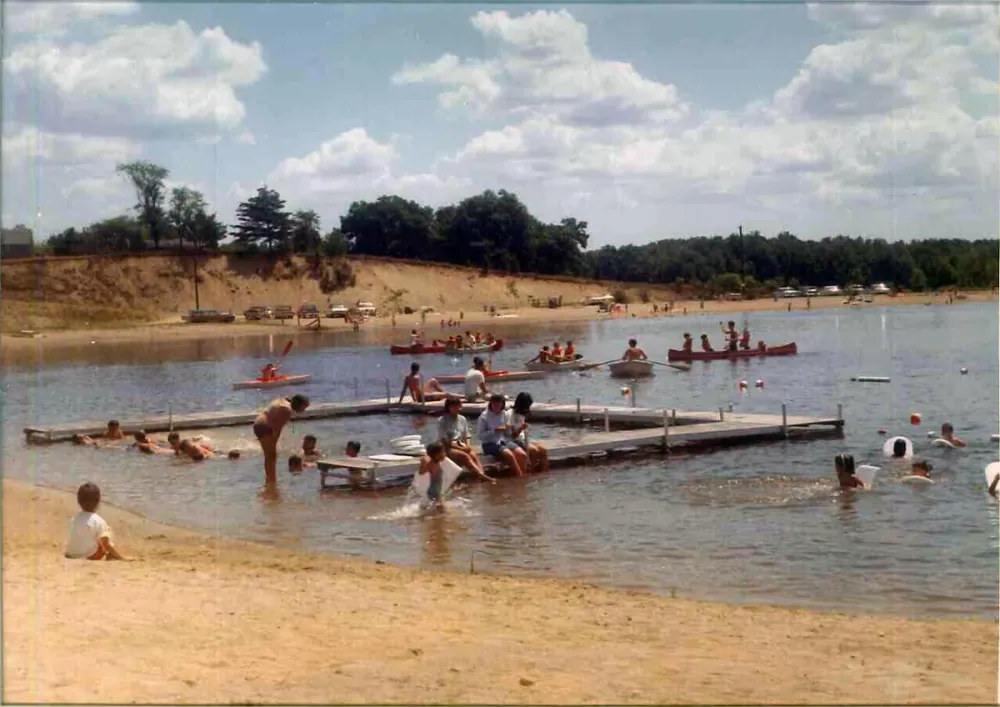 Vintage photo of a group of people standing on a beach next to the lake at Maplewood