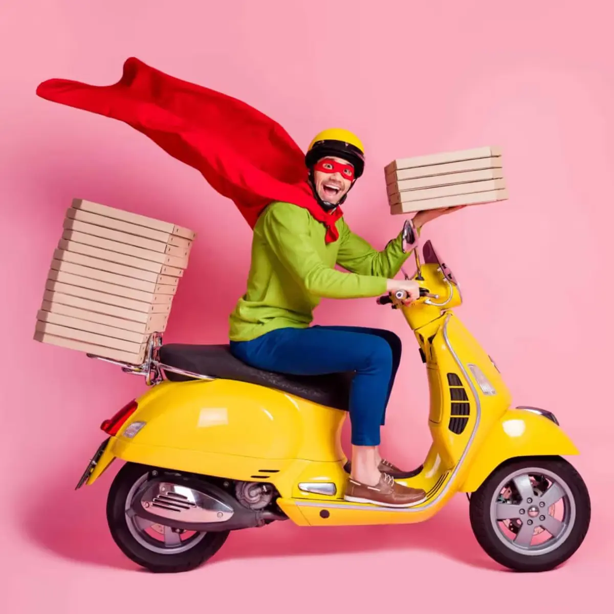 a caped delivery man on a yellow scooter holding a stack of pizza boxes