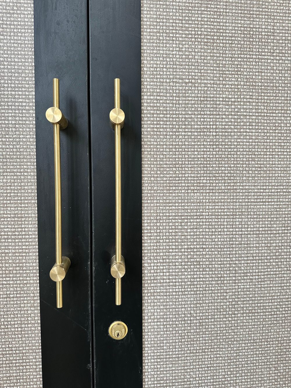 Black PU shutter beside a woven linen panel with brass T-handles