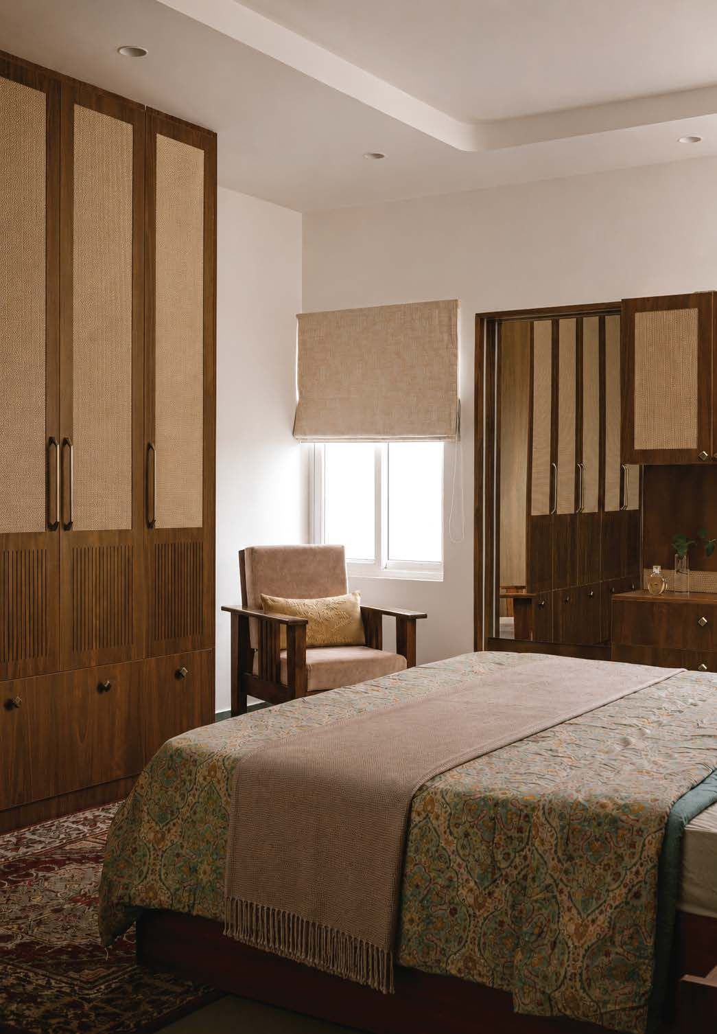 A calm bedroom suite with cane-front wardrobes and layered textiles