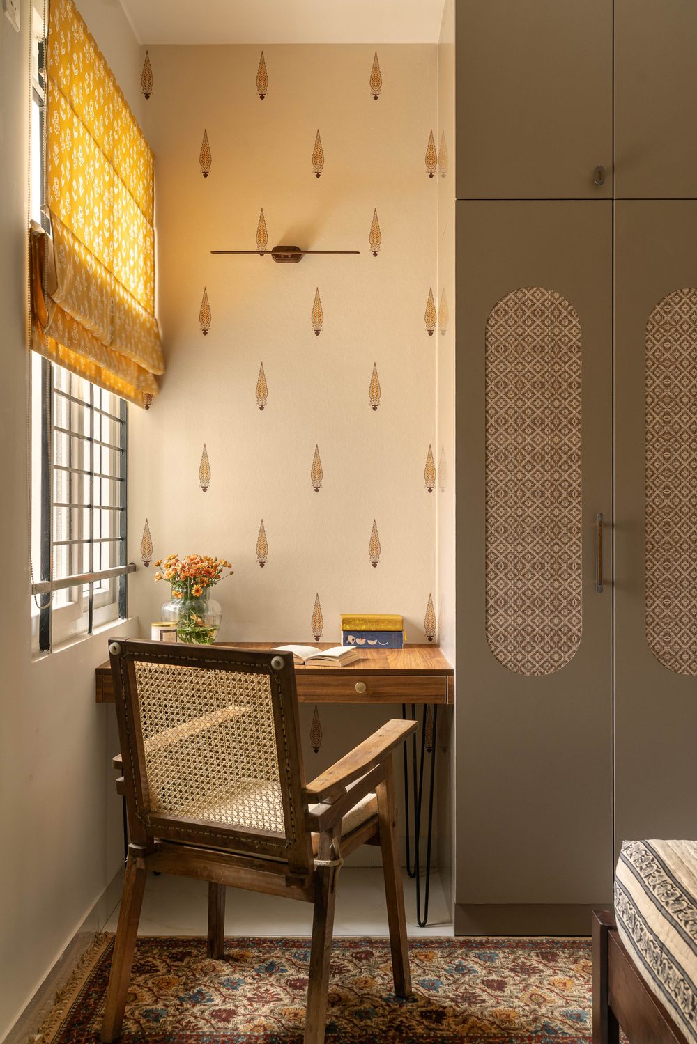 Wardrobe with brass inlay beside gold chinoiserie wallpaper