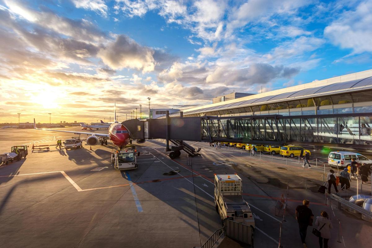 The red commercial airplane grounded on the tarmac, viewed from below, represents the urgency of supplier risk assessment in modern aviation.