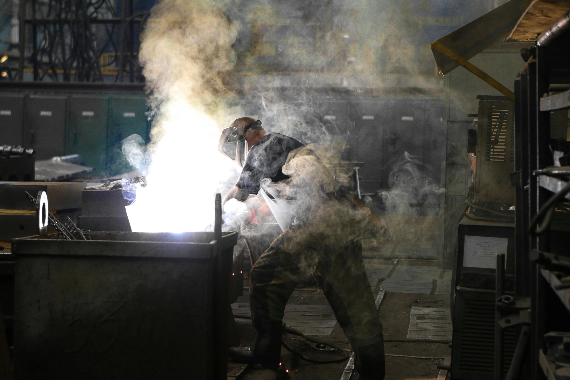 Un tecnico indossa un equipaggiamento protettivo mentre esegue lavori di saldatura in officina.