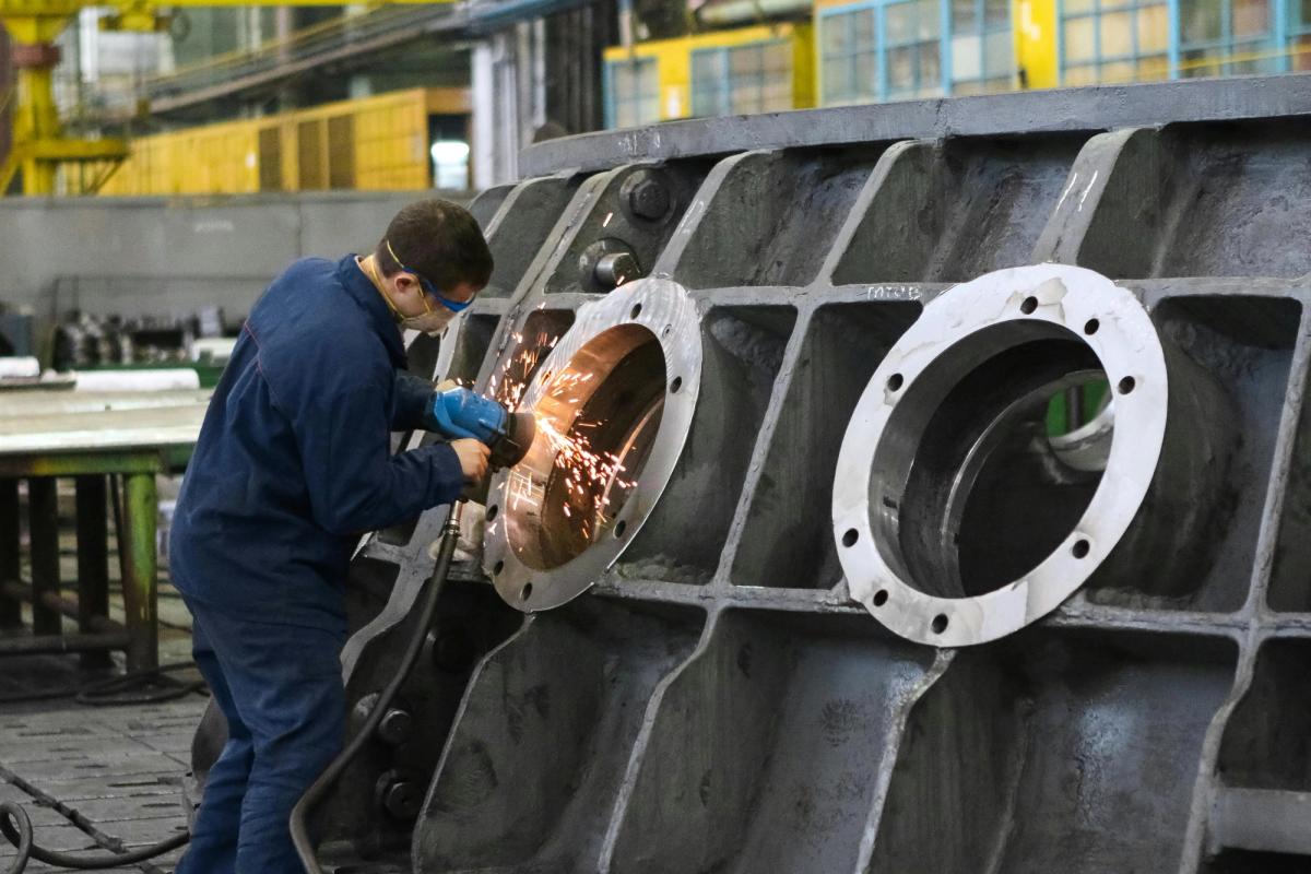A technician grinds a component as part of a lean manufacturing workflow, which reduces rework, improves flow, and enables faster aircraft assembly.