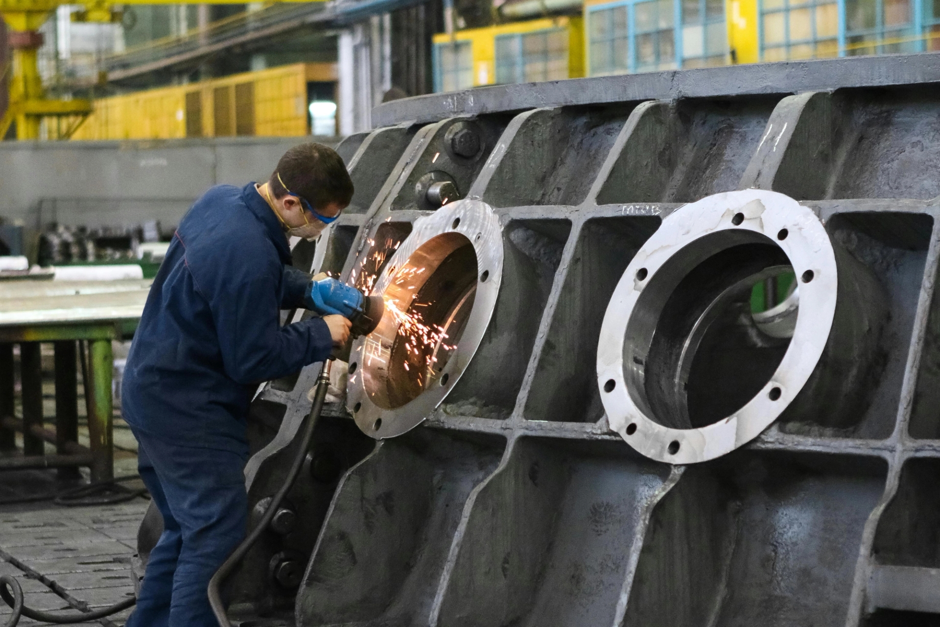 Ein Techniker schleift im Rahmen eines schlanken Fertigungsablaufs ein Bauteil, wodurch Nacharbeiten reduziert, der Ablauf verbessert und eine schnellere Flugzeugmontage ermöglicht wird.