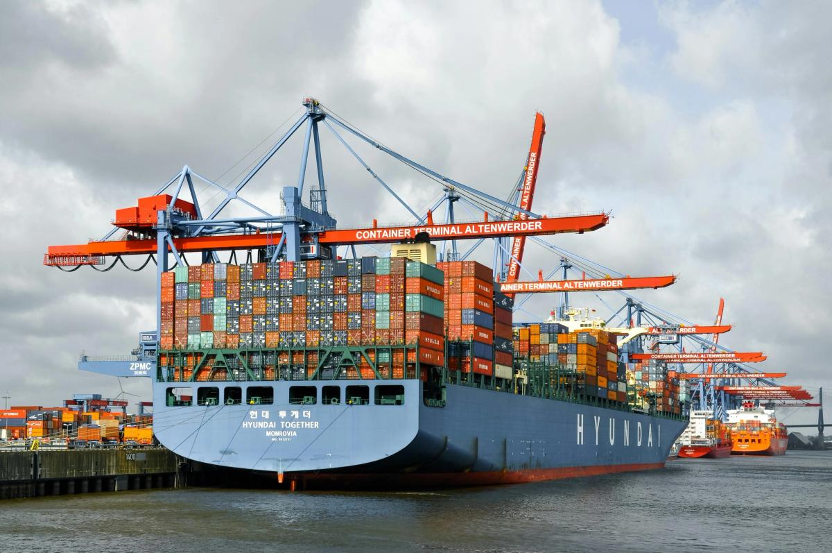 A freighter ship enters the harbor loaded full with containers.