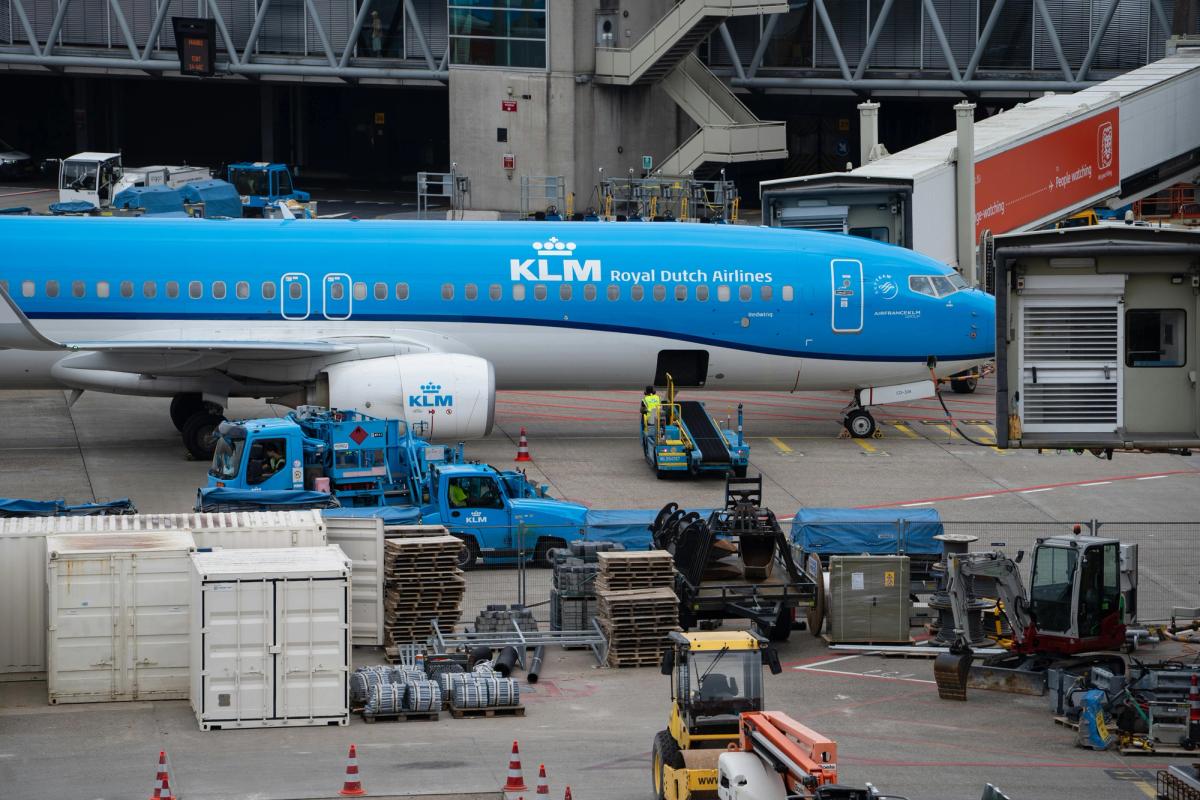 A KLM aircraft docked at an airport terminal during ground operations, representing the critical role of efficient maintenance scheduling in minimizing turnaround time and keeping fleets on schedule.