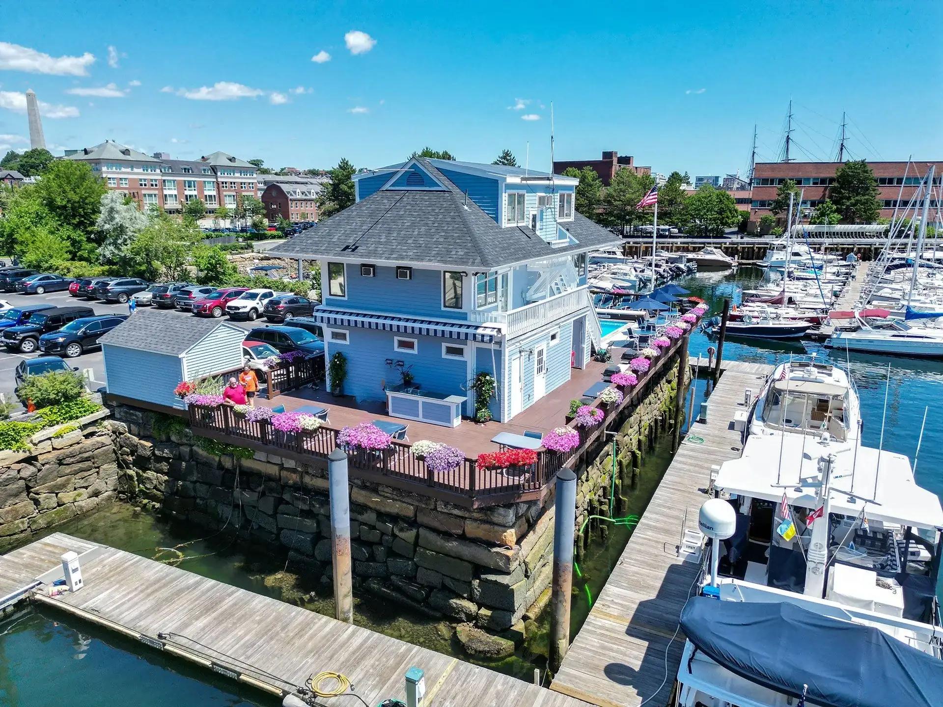 Floating docks and boats beside the blue marina office at Constitution Marina
