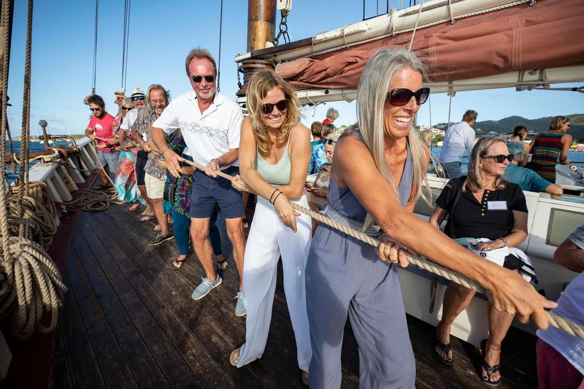 Guests hauling a line together on a schooner deck