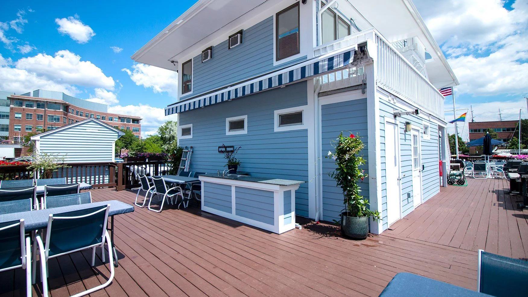 A two-story building with a deck and outdoor furniture