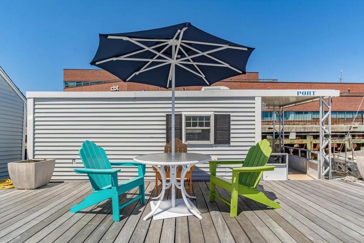 The private deck outside the houseboat Port, with a table, umbrella and chairs