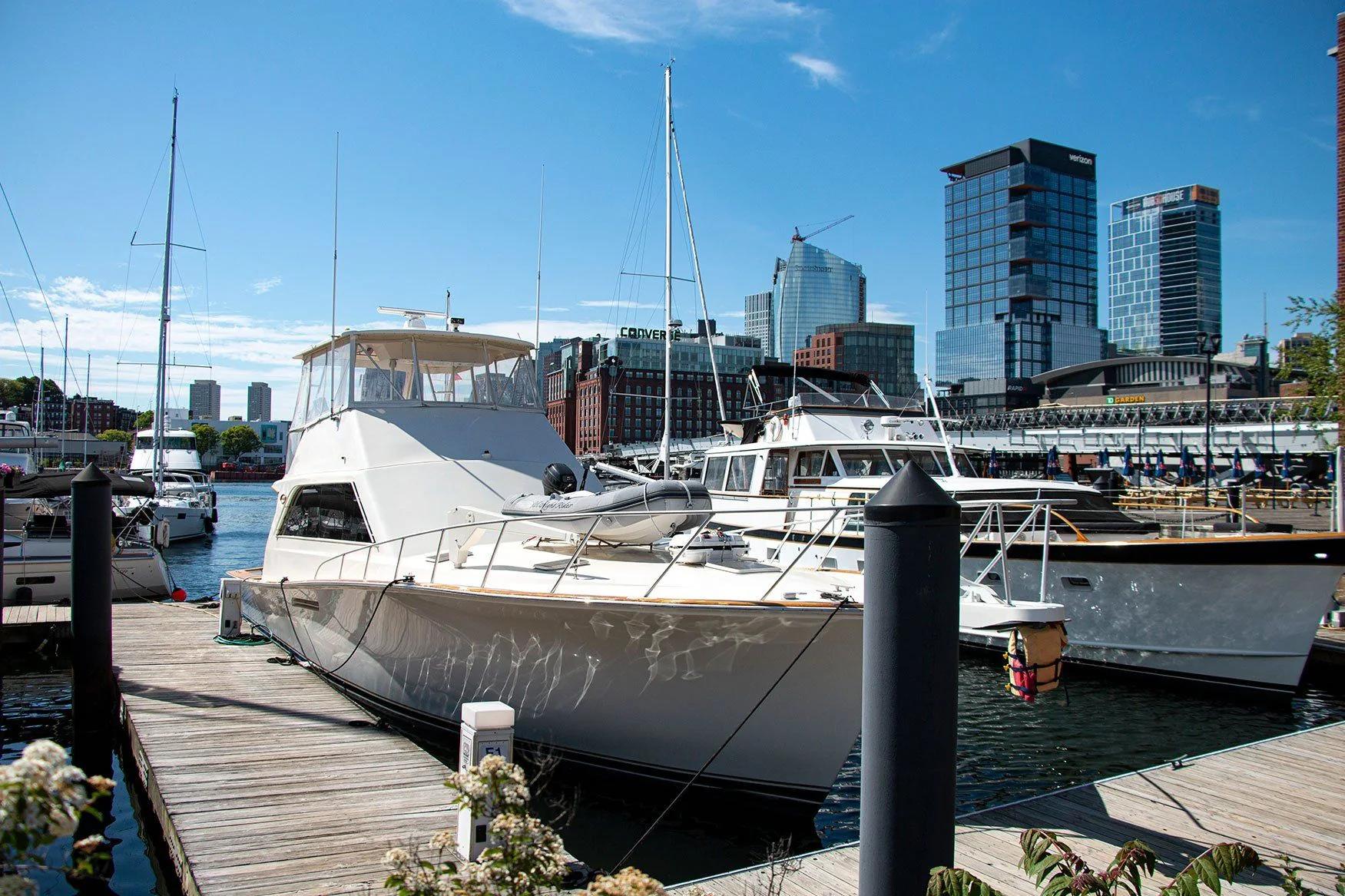 Motor yachts moored beside the docks with the Boston skyline behind