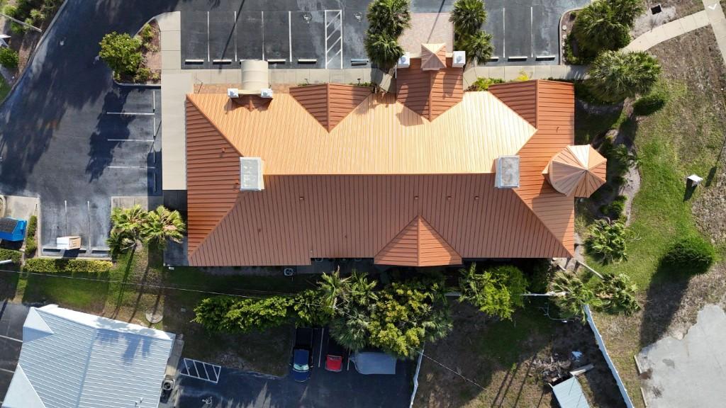Copper-colored standing-seam metal roof on a commercial building in Largo, seen straight down from a drone