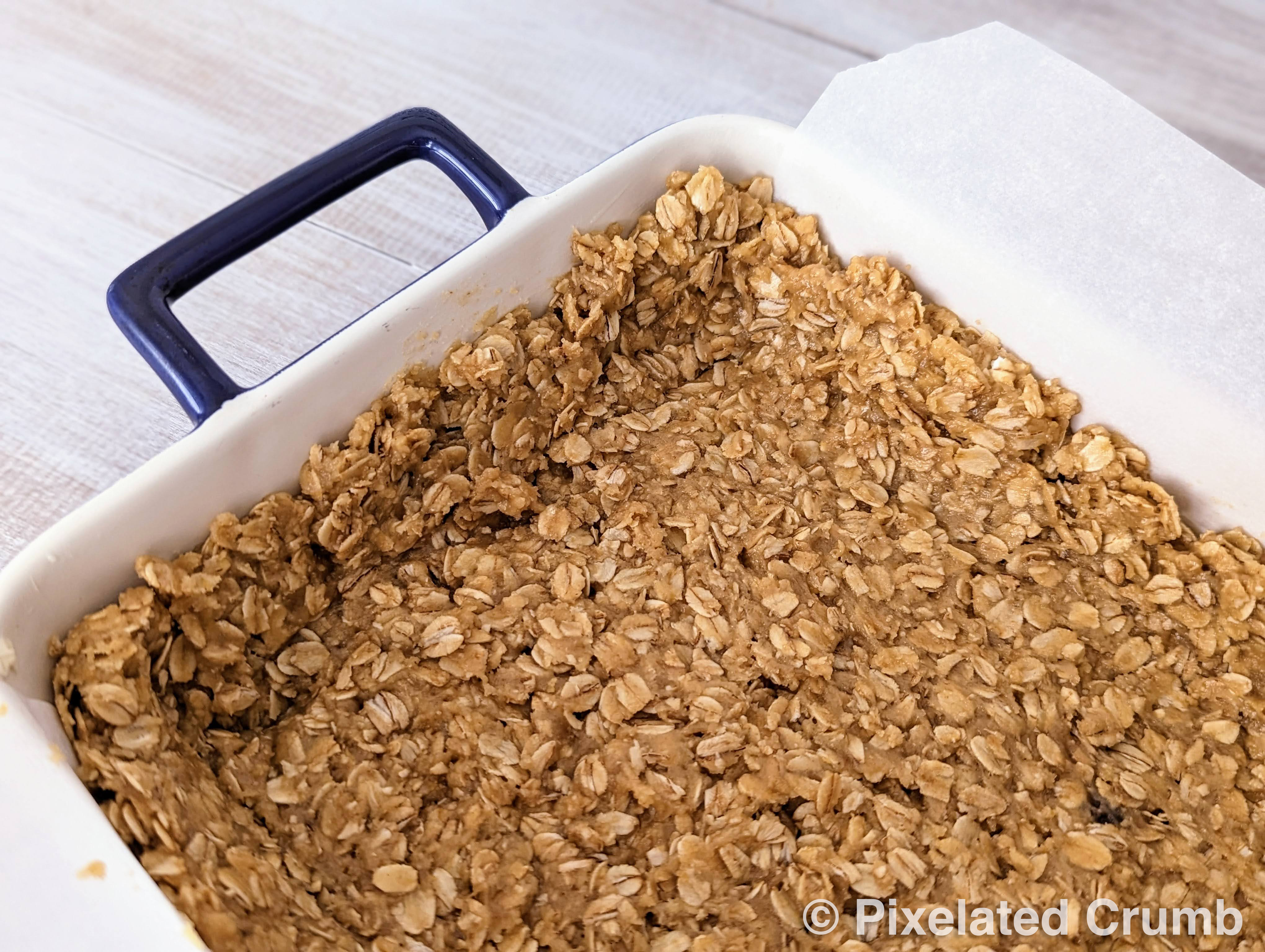brown sugar and oat mixture spread into baking pan across the bottoms and up the sides