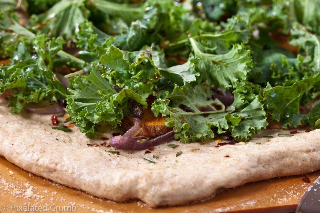 Kale, sweet potatoes, red onion, and fresh rosemary on pizza dough