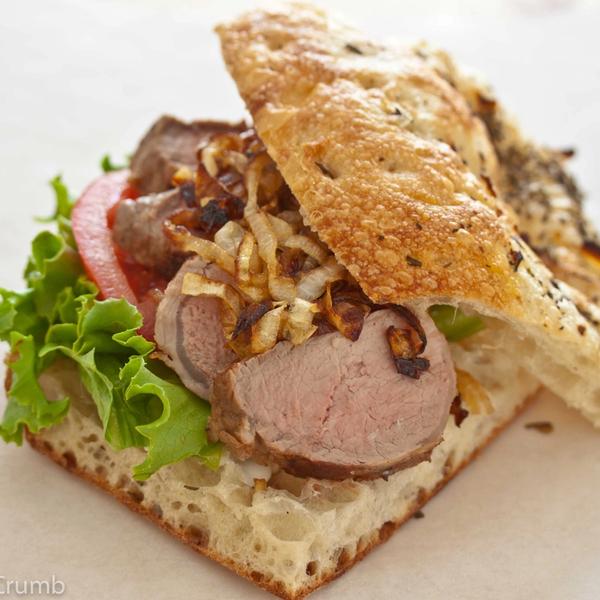 Bifana – Portuguese Sliced Pork Tenderloin Sandwich with Caramelized Onions and Garlic Aioli on Focaccia Bread