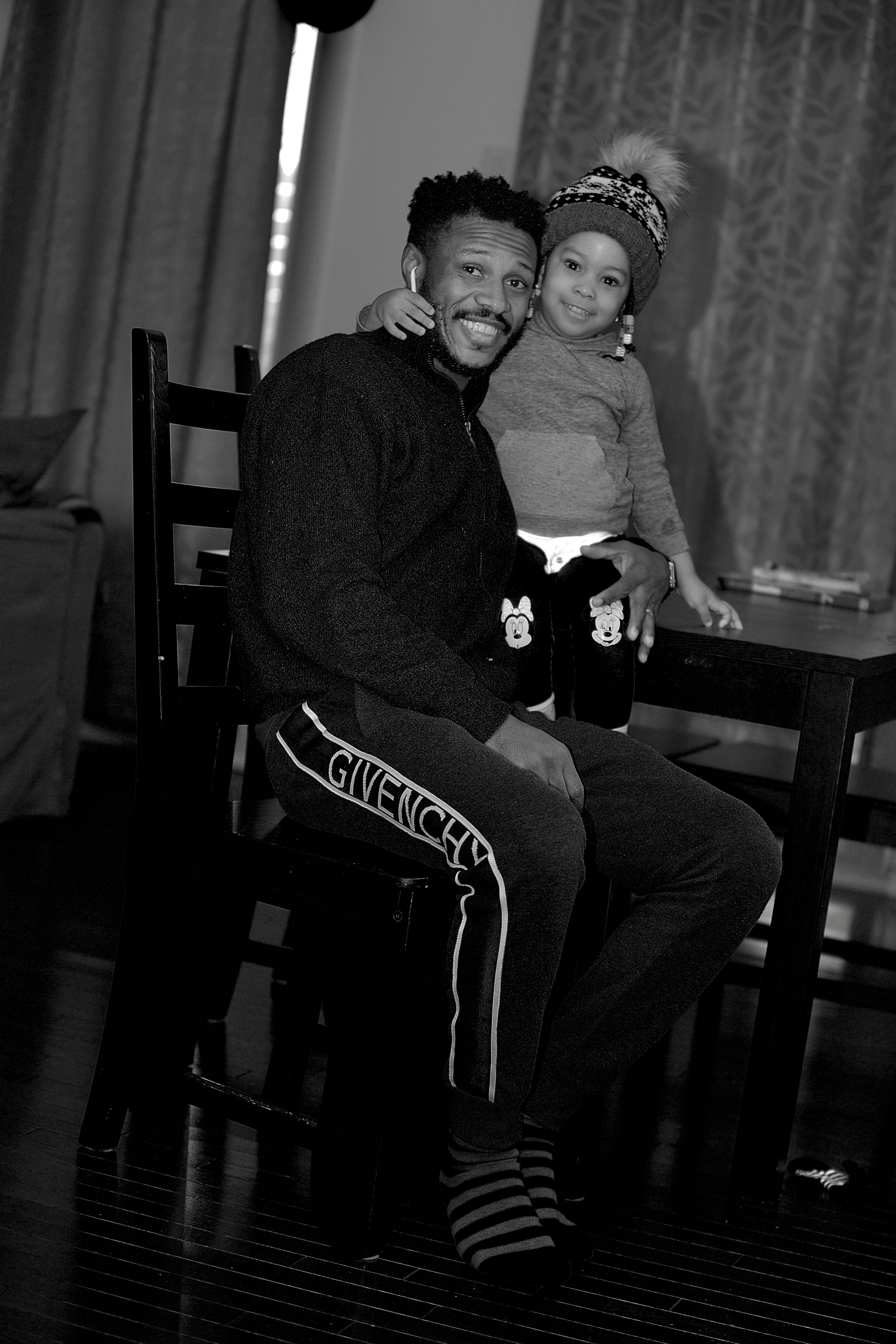 Father and daughter side by side at the kitchen table, black and white