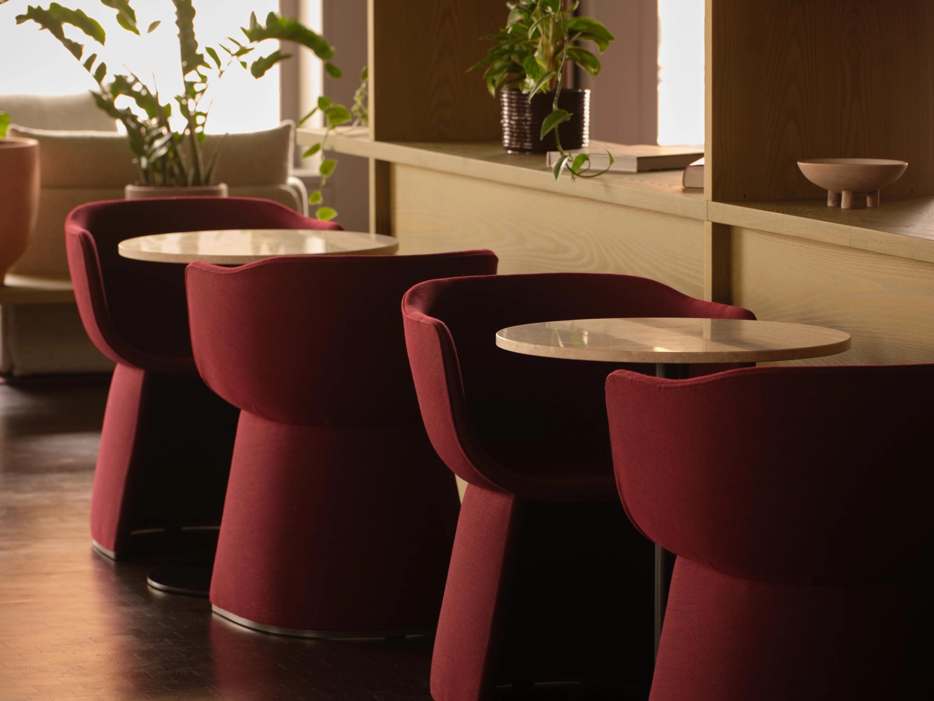 A modern office space showing a table with chairs around it, a divider in the middle of the table and nicely lit alcove cupboards surrounding a fireplace at the far end.