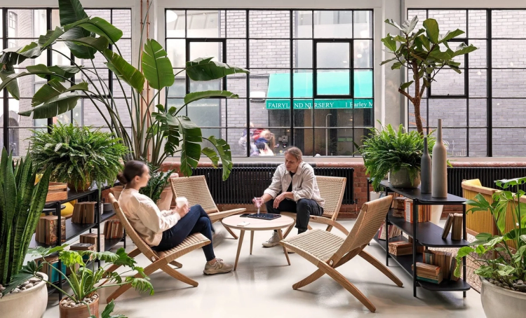 A couple of people sat in some deck-chair-like chairs around a round table, enjoying drinks