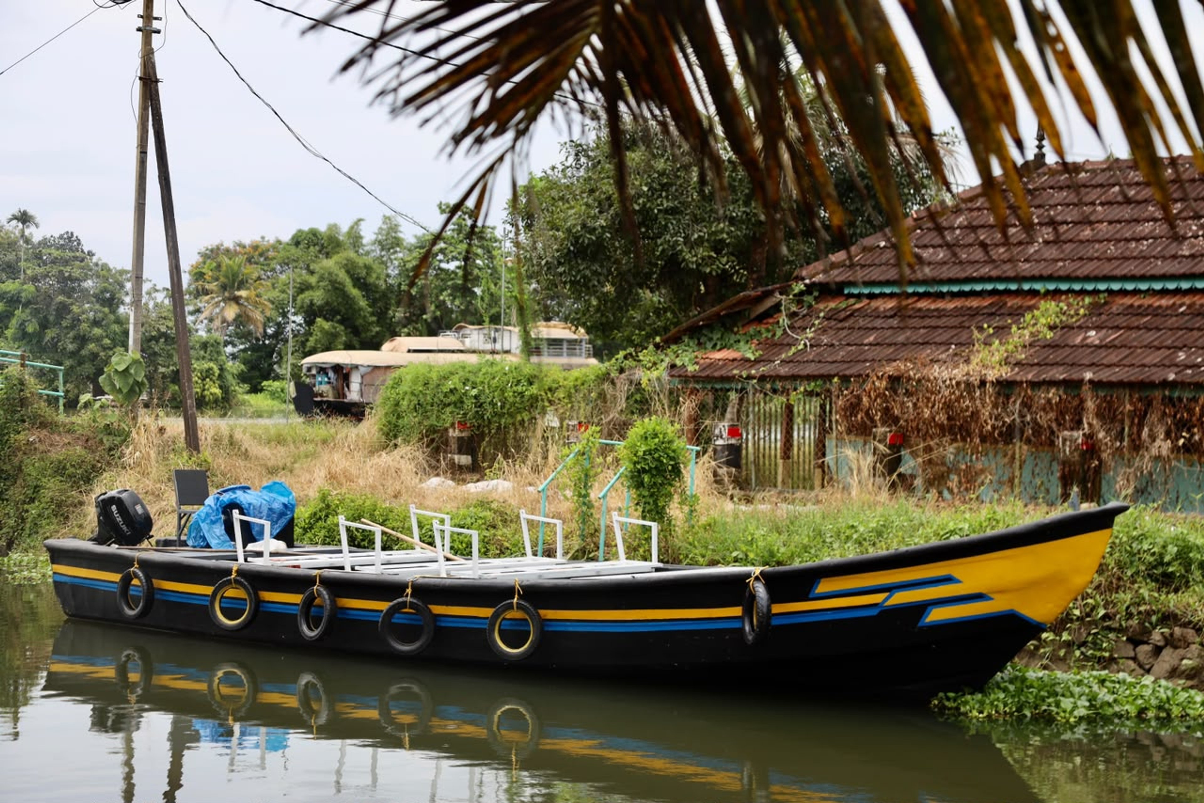 Open motorboat with bench seats moored in a village canal in Alleppey