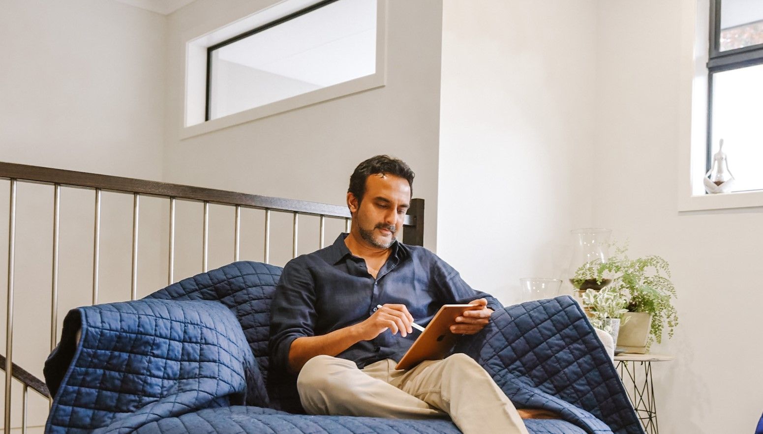 Person on a couch on and using an iPad