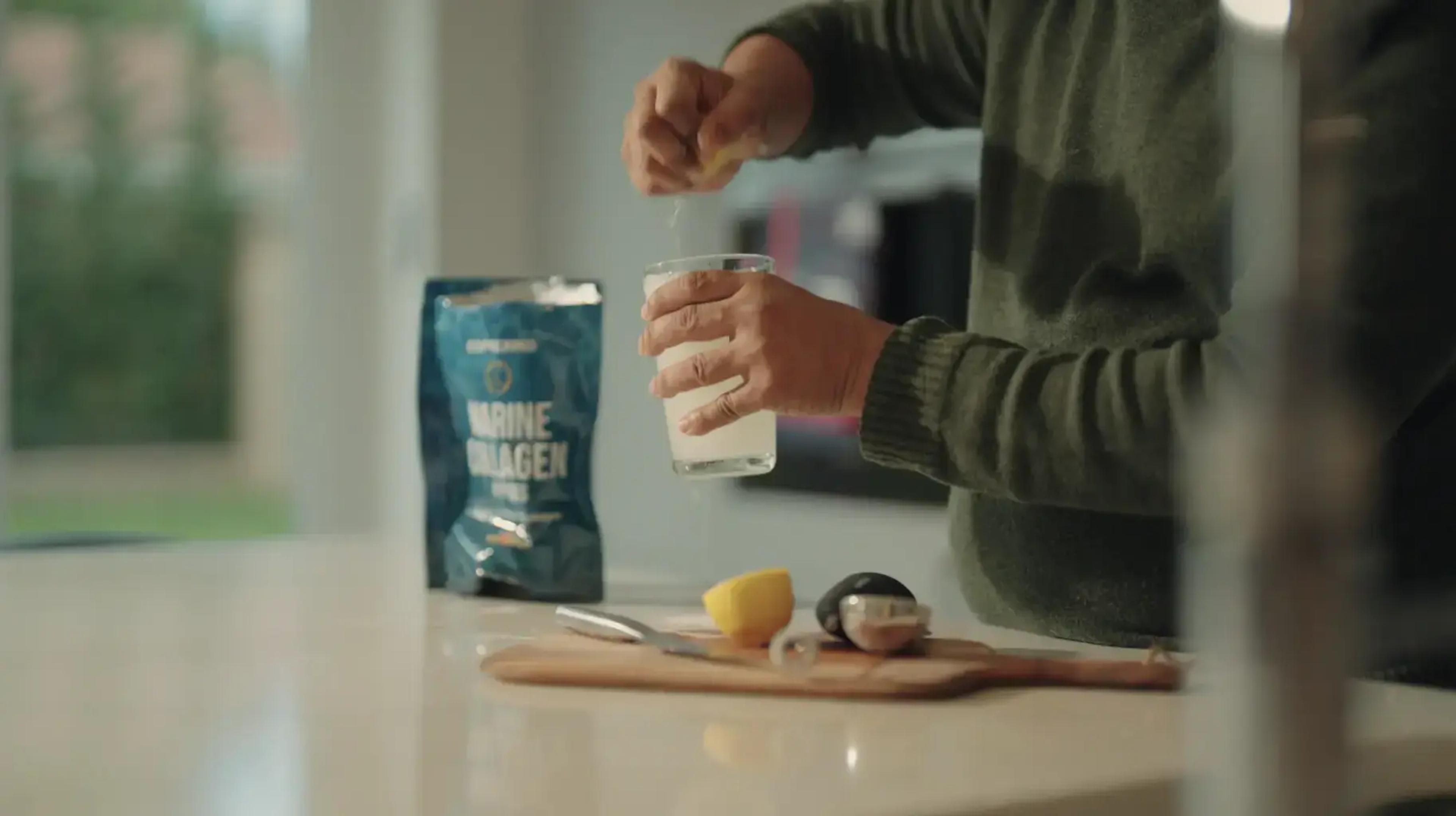 Alguien mezclando correxiko en un vaso en la cocina