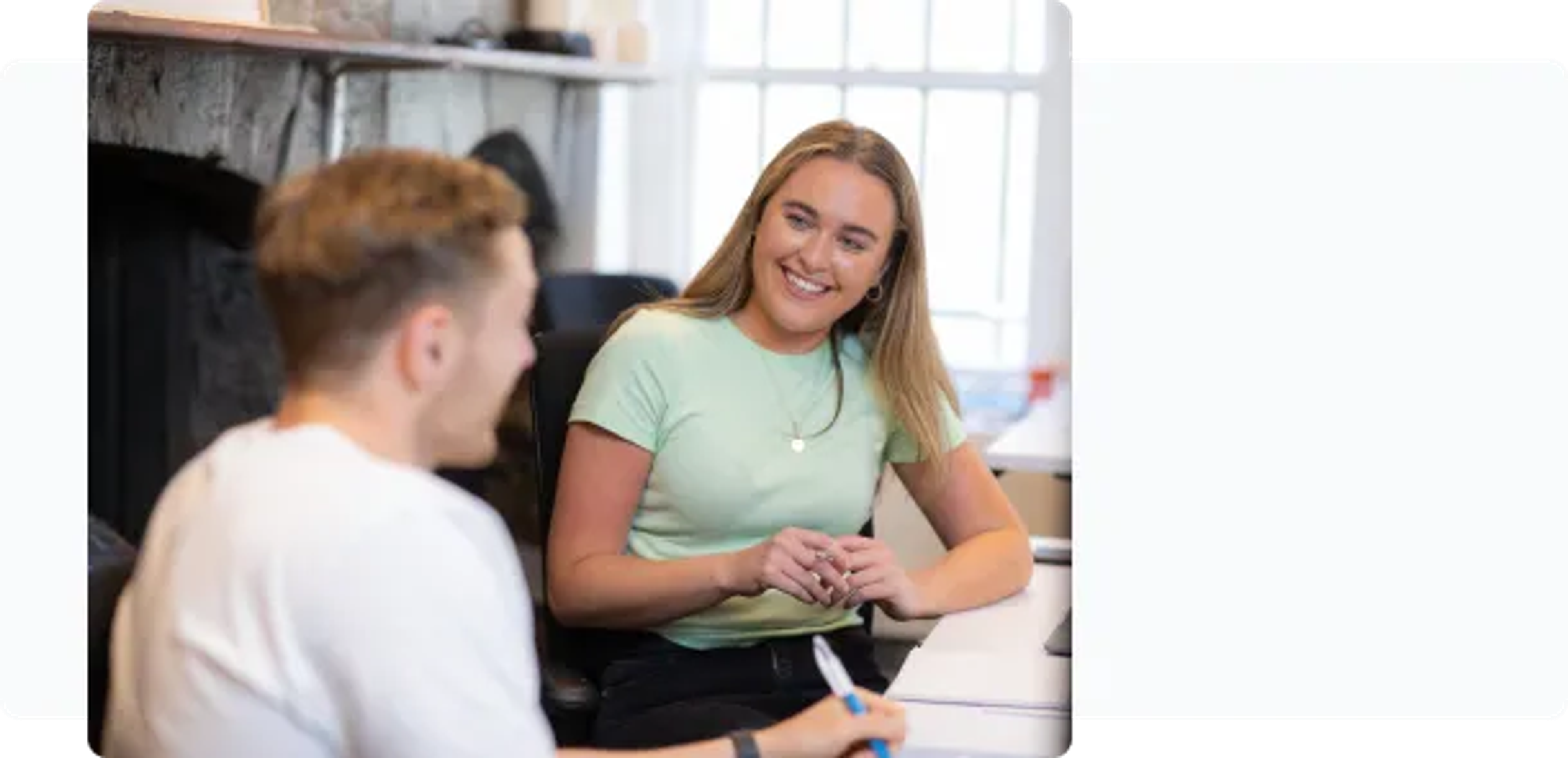 Two people at a desk smiling