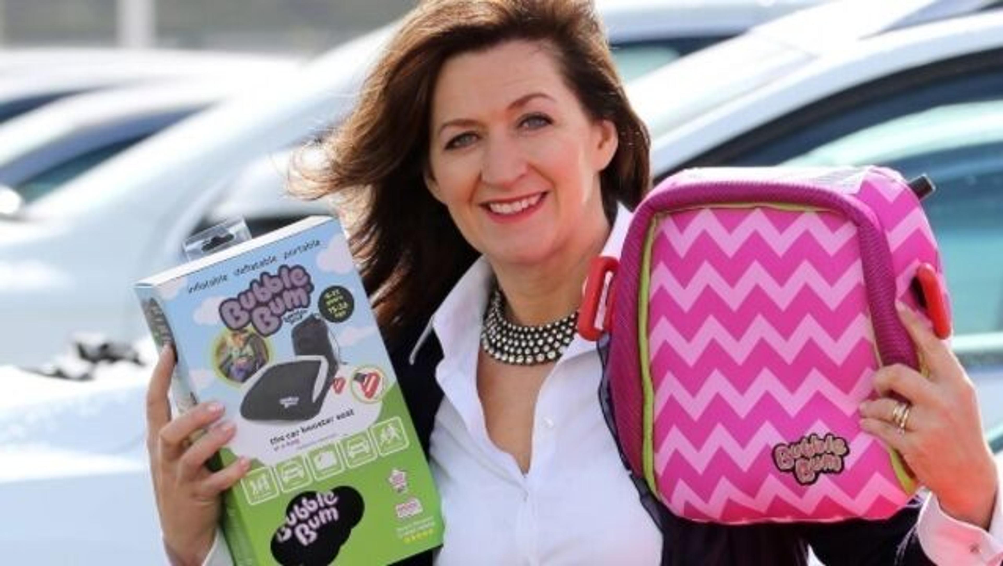 Grainne met de BubbleBum stoelverhoger in de hand