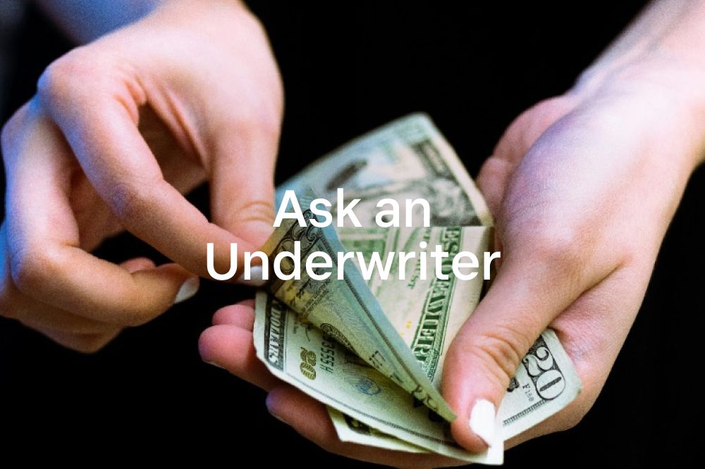 Bargeld in Händen mit dem Titel „Fragen Sie einen Underwriter“