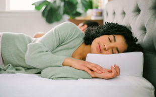 Person lying in bed with Pillow Cube