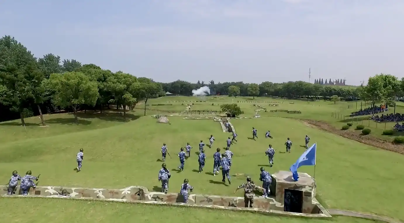 Young men and women don soldier uniforms practicing in a field