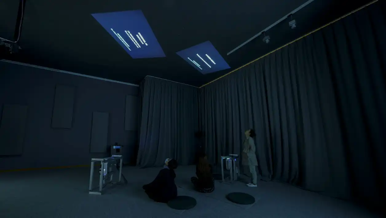 Ceiling projects in a dark room, surrounded by curtains