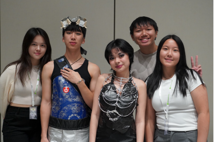 A group of people standing in front of a wall.