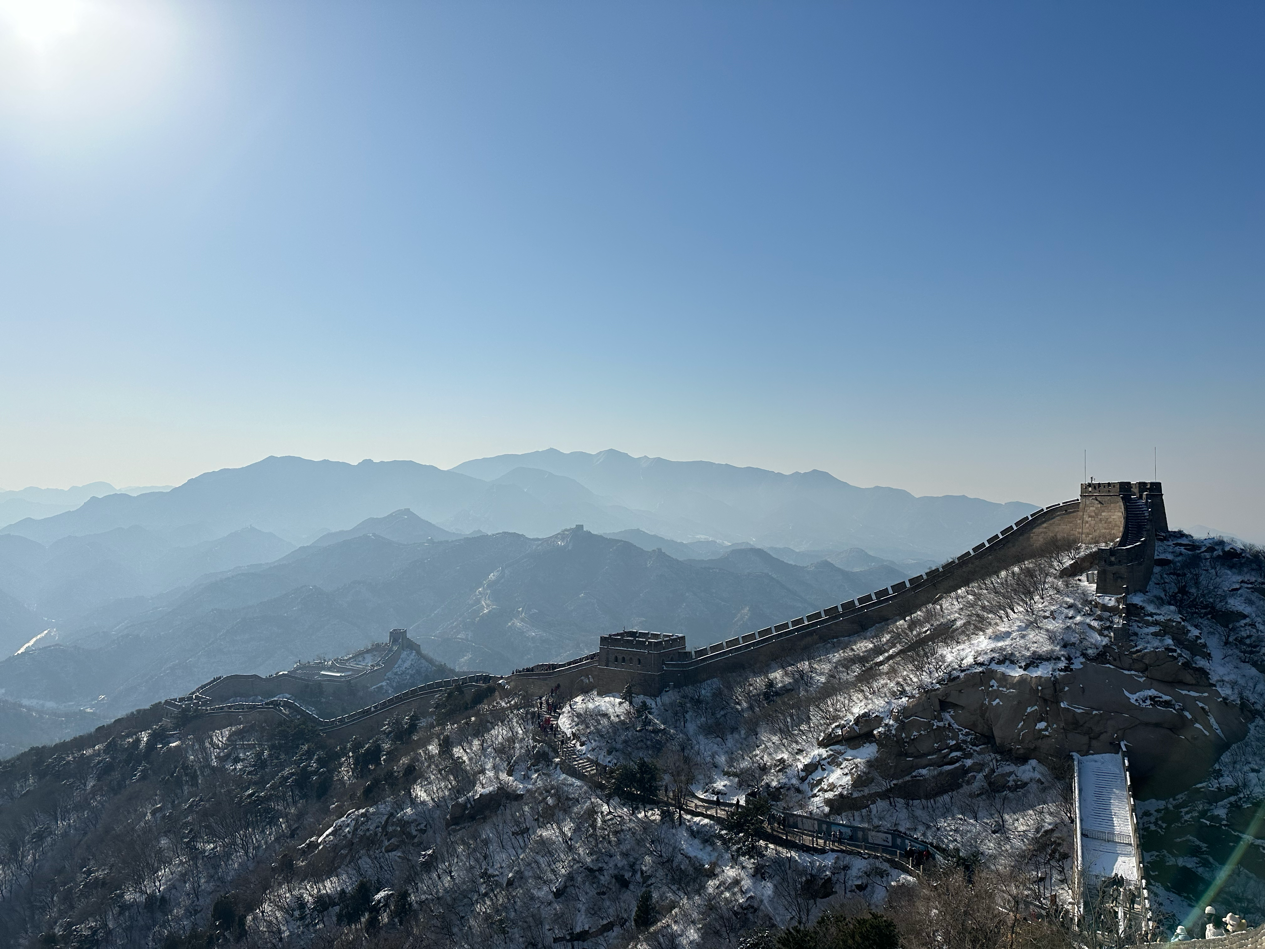 Great Wall covered with snow, mountains in background