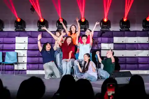 The cast of the 2025 Reality Show pose on the stage.