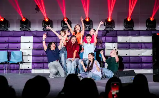 The cast of the 2025 Reality Show pose on the stage.