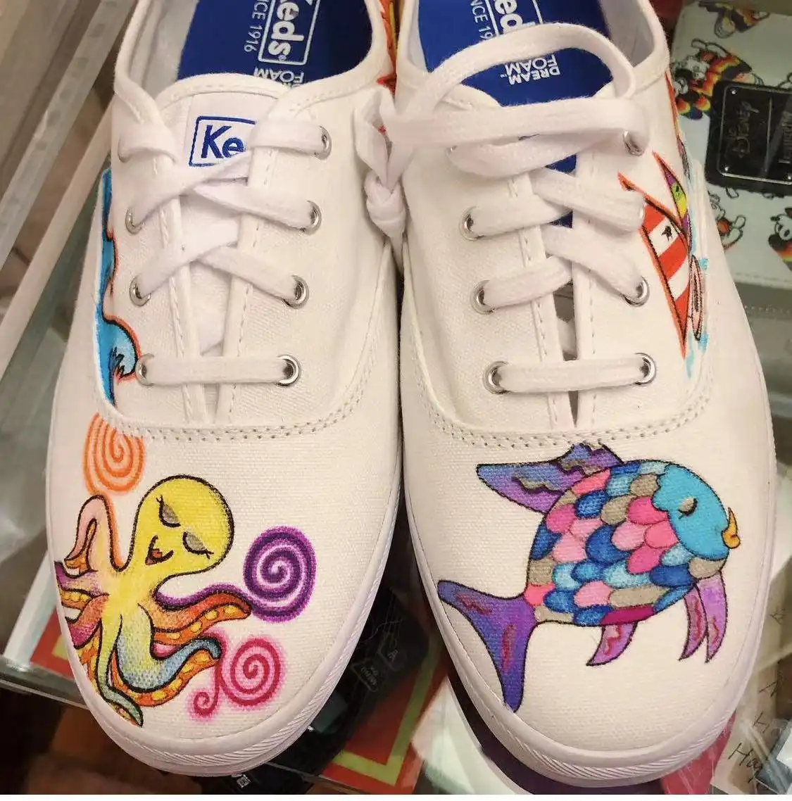 An octopus and a fish drawn on a pair of white sneakers